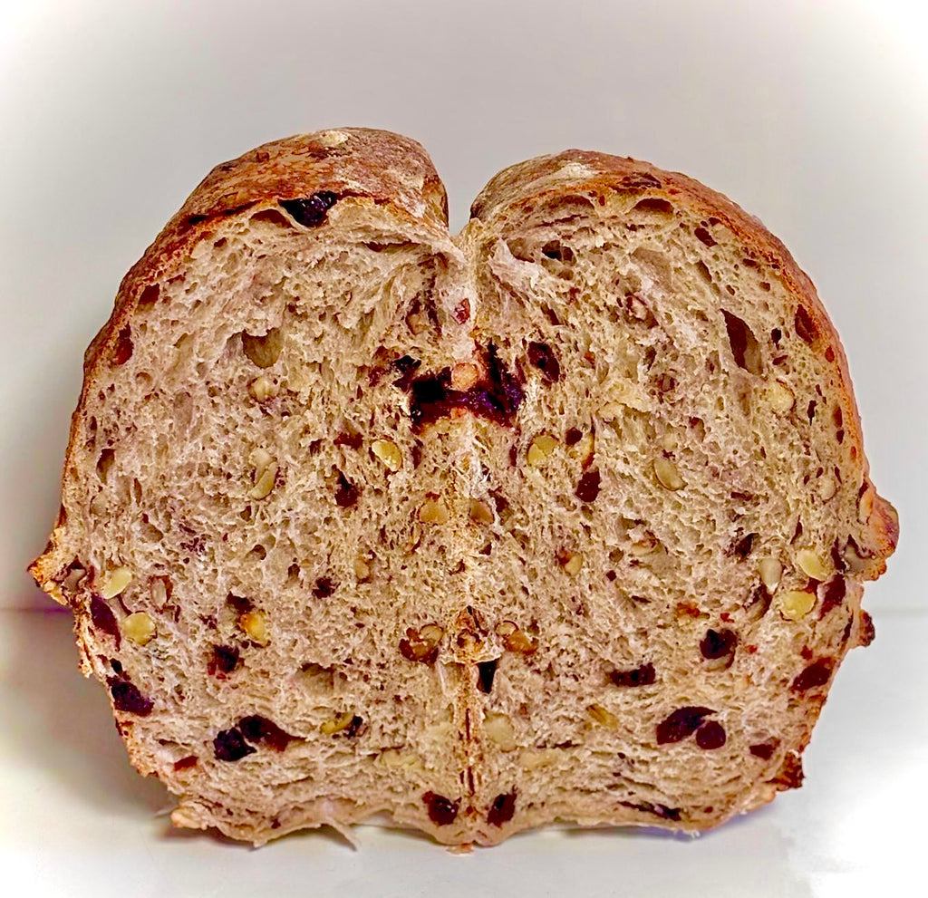 Sliced loaf of bread with visible seeds on a white background