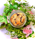cookie on a glass jar with greenery and flowers on a white background