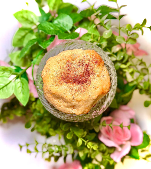 cookie on a glass jar with greenery and flowers on a white background