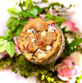 cookie on a glass jar with greenery and flowers on a white background