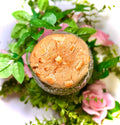 cookie on a glass jar with greenery and flowers on a white background