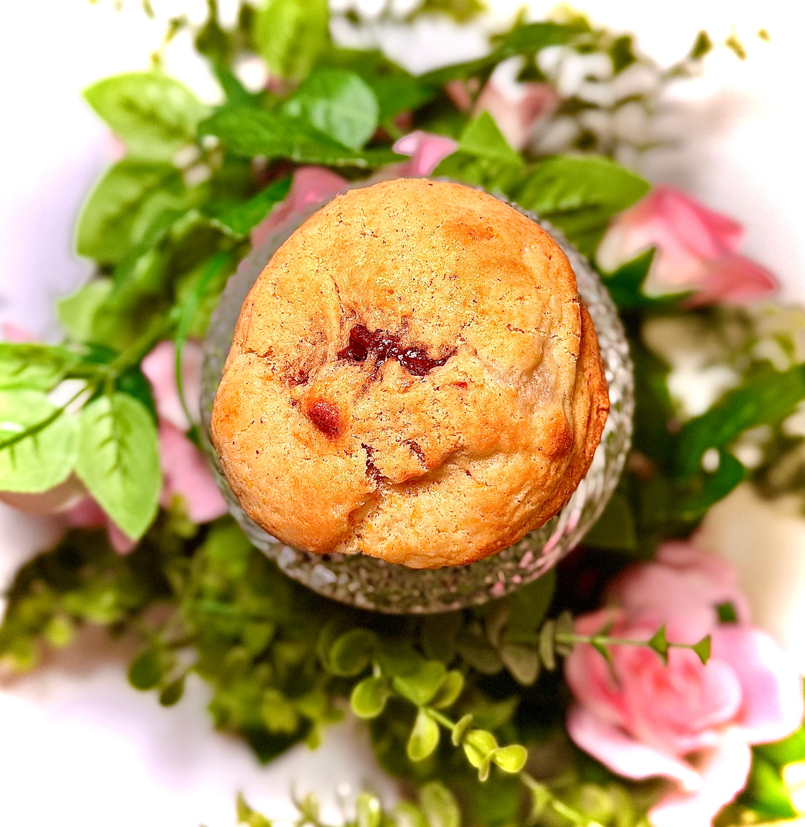 cookie on a glass jar with greenery and flowers on a white background