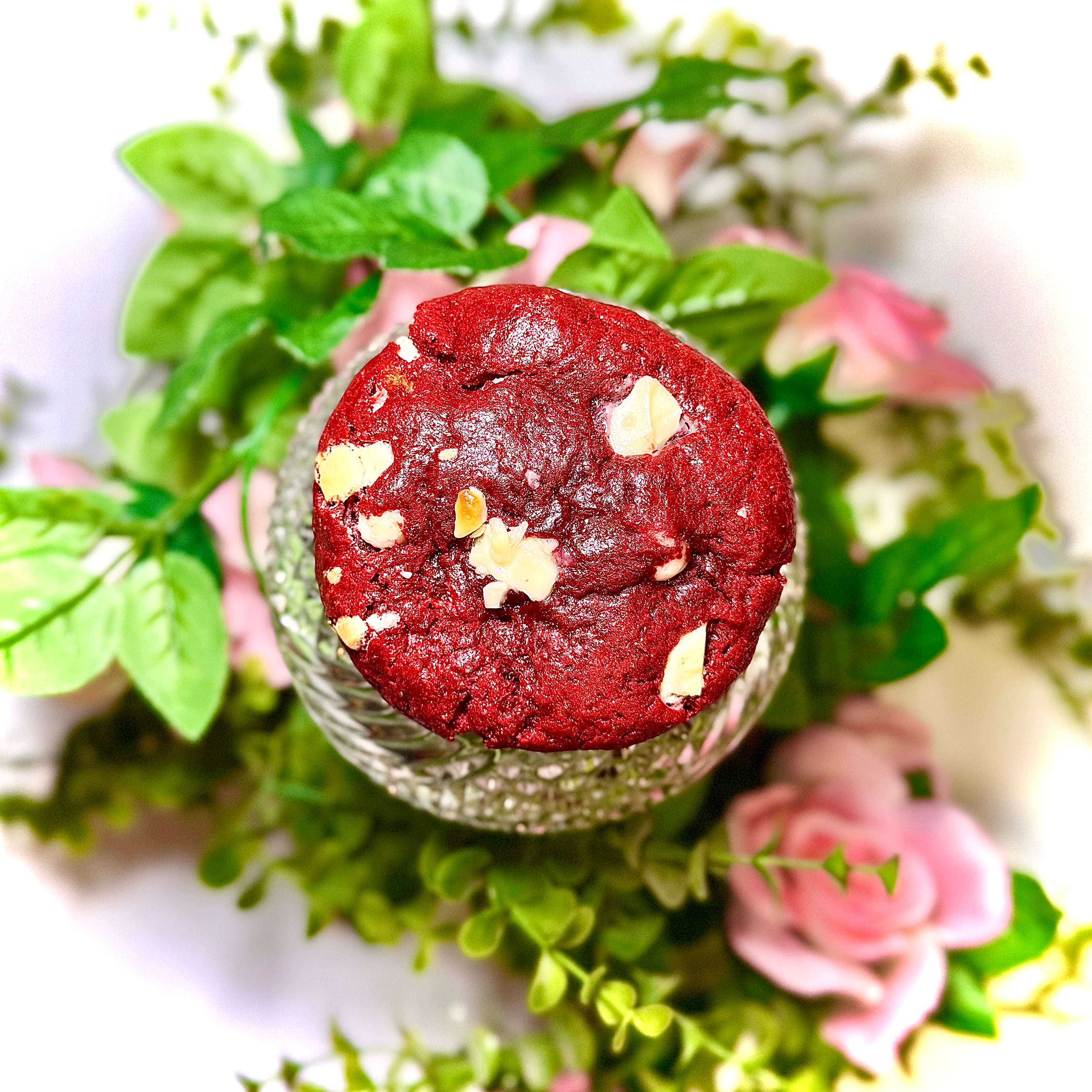 cookie on a glass jar with greenery and flowers on a white background