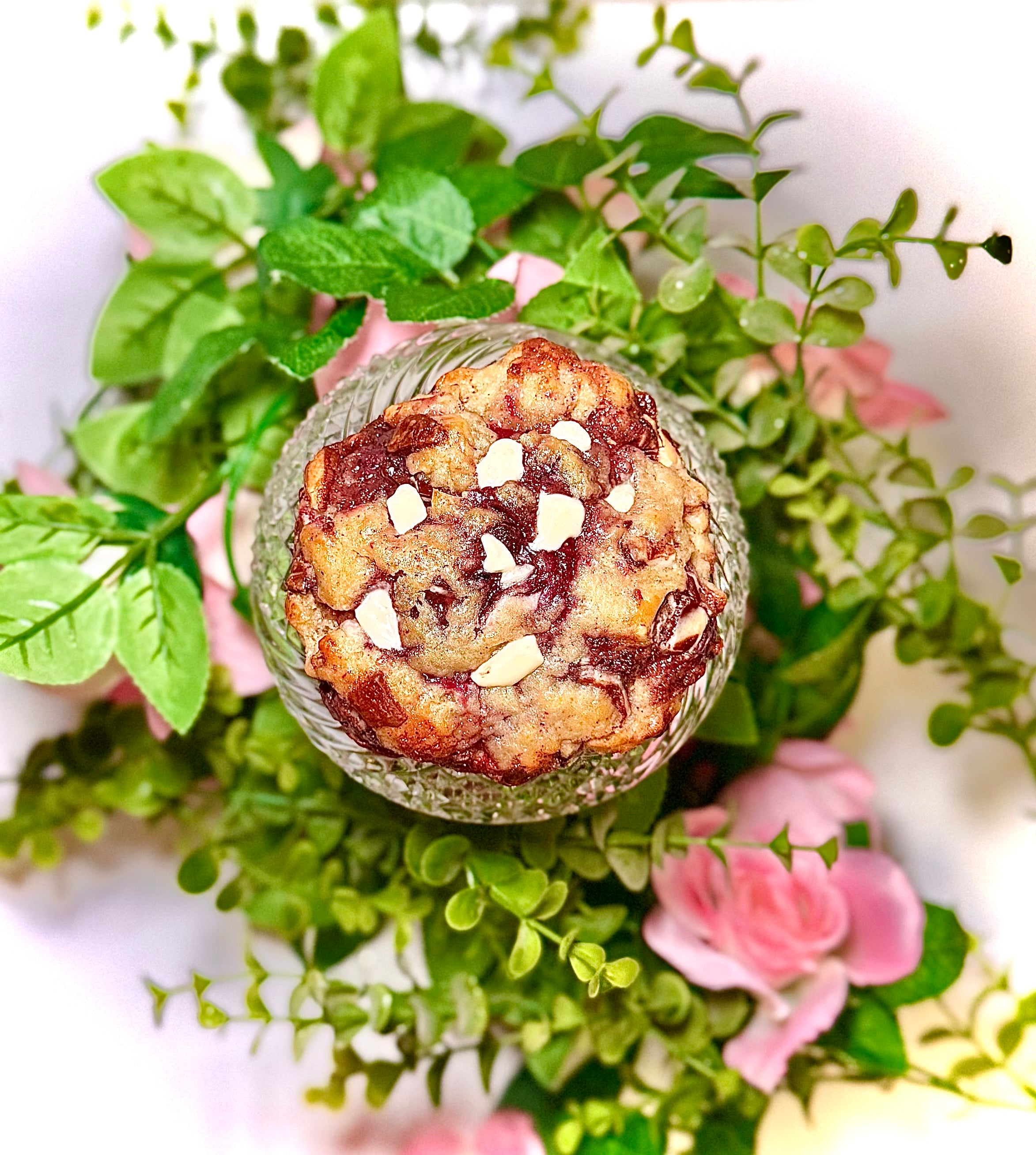 cookie on a glass jar with greenery and flowers on a white background