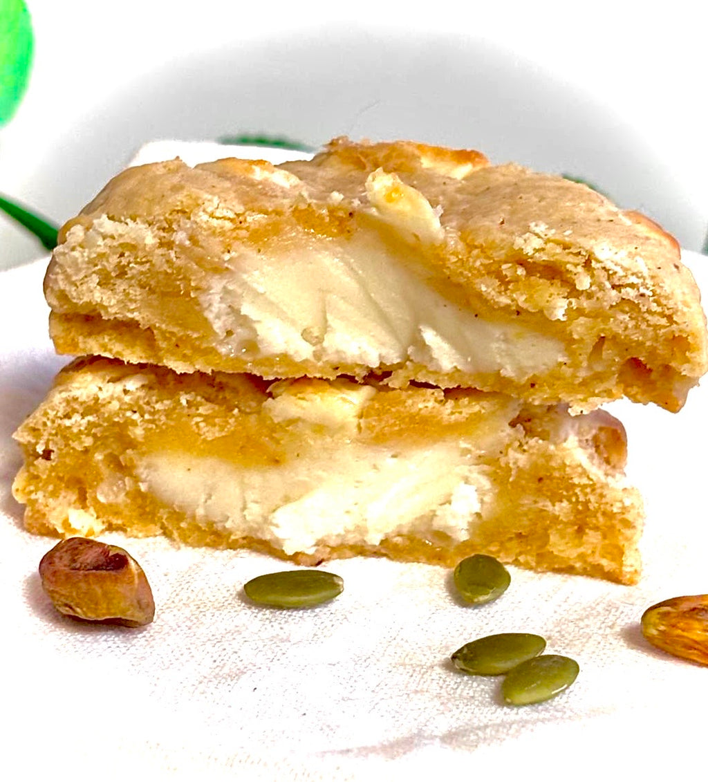 Cookie with cream filling on a white plate with pumpkin seeds.